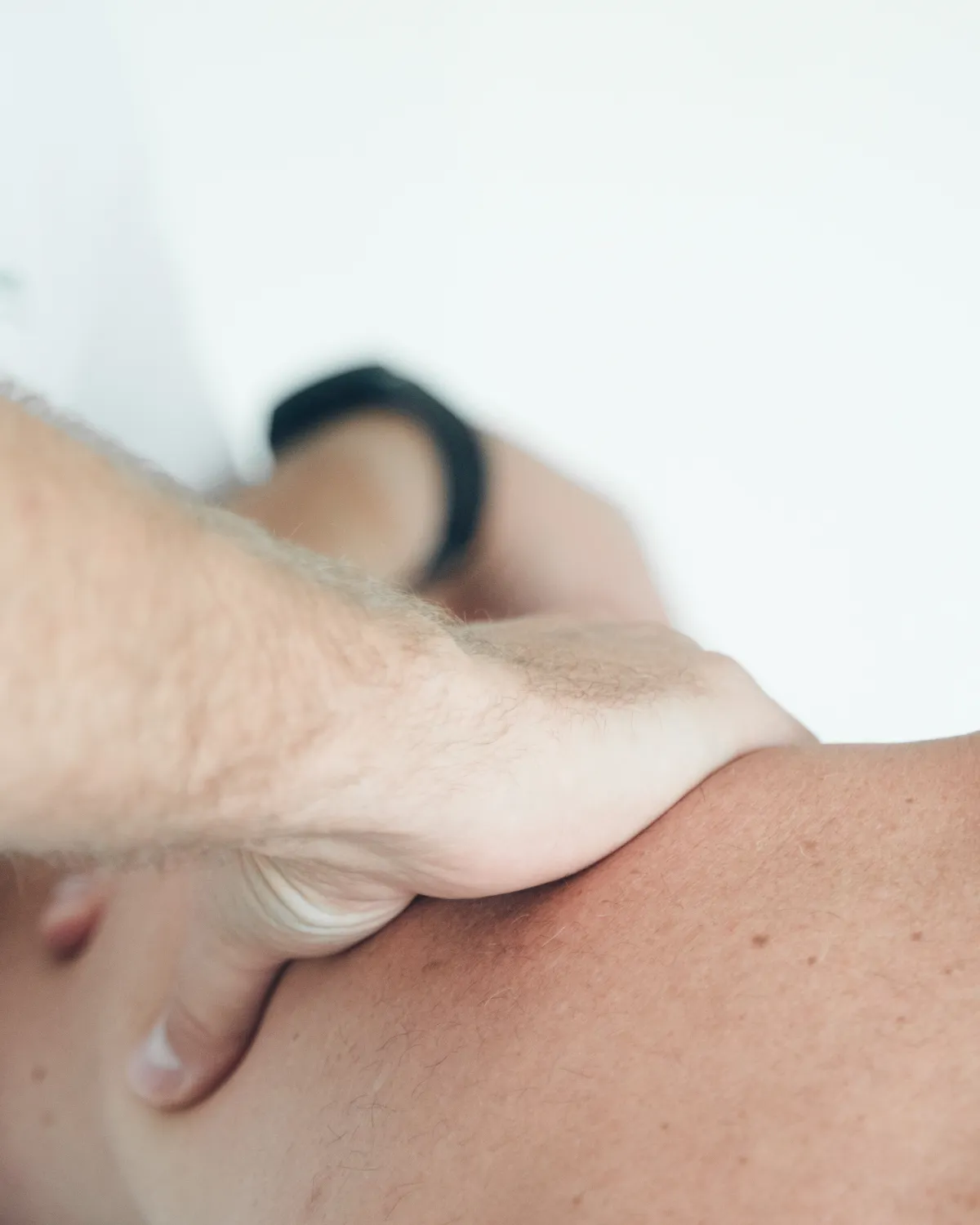 Ruhig aufgelegte Therapeutenhand an der Schulter eines Patienten